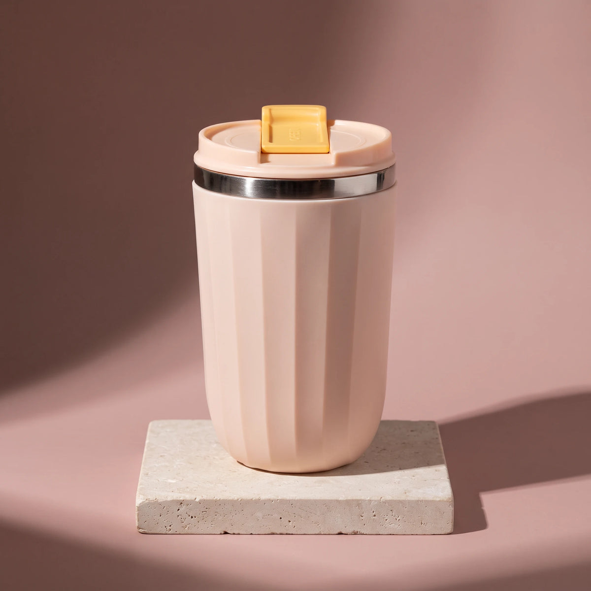Opal travel tumbler, Blush Pink, on a stone tile, coloured backdrop