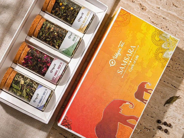 Printed festive tea gift box holding whole leaf teas in glass jars