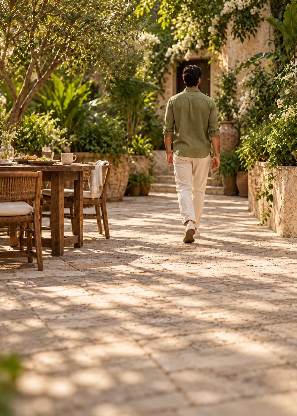 Man taking an easy stroll across a sunlit courtyard
