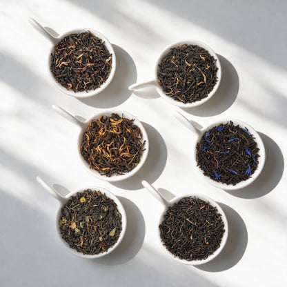 The six loose teas in the Black Tea Sampler Pack, in white bowls