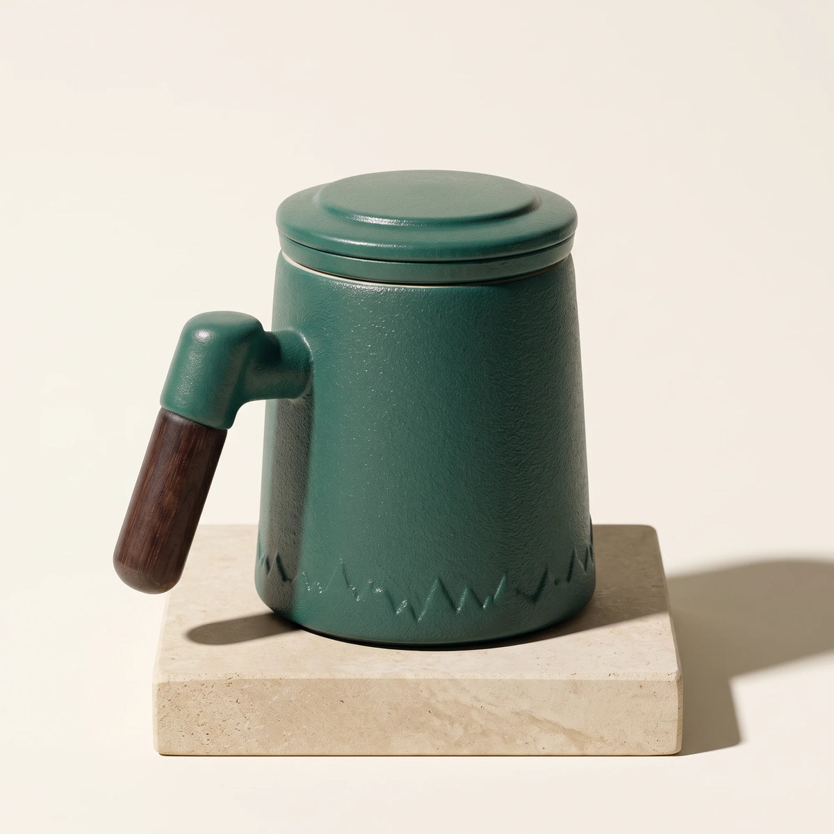 Everest ceramic tea infuser mug, Forest Green, on a stone tile