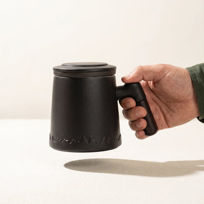 Everest ceramic tea infuser mug, Noir Black, held by the handle