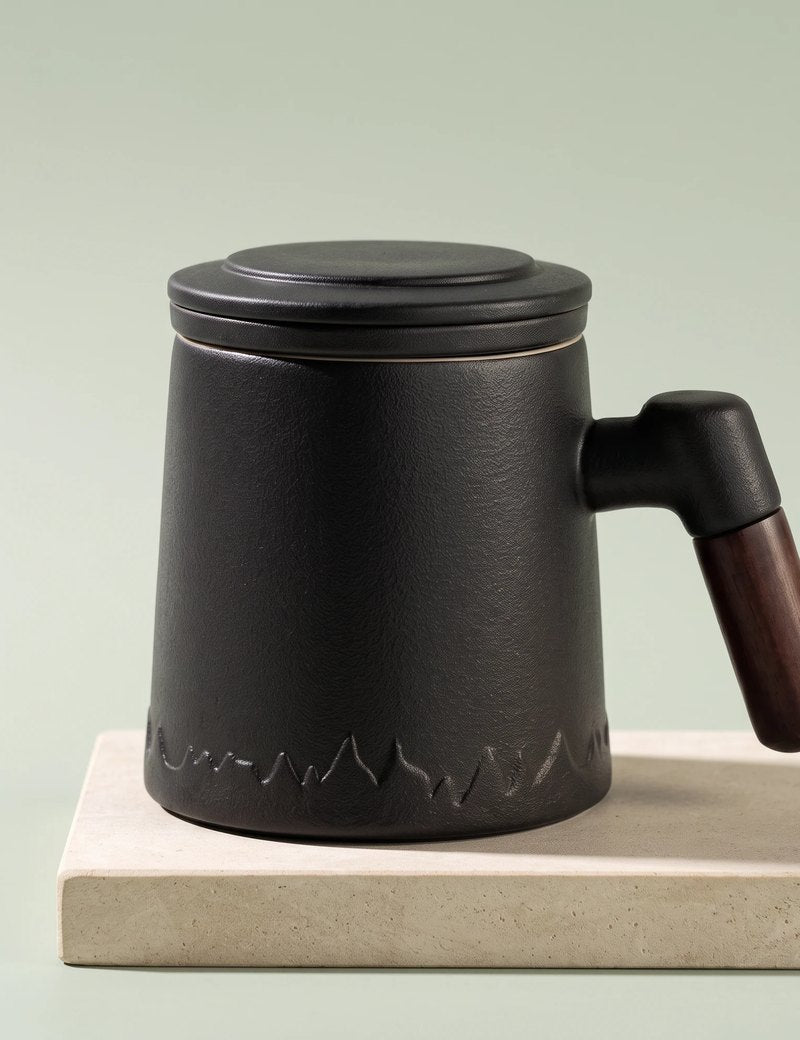 Everest tea infuser mug, Noir Black, on a stone tile