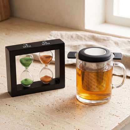 Happy Hour tea timer beside a glass mug of tea with an infuser