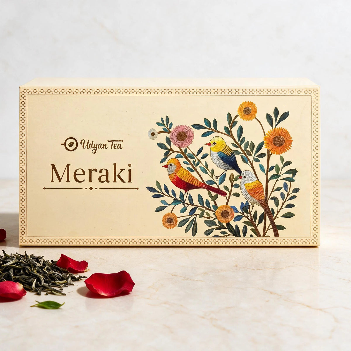 Meraki tea gift box, cream with birds and flowers, beside loose tea and rose petals