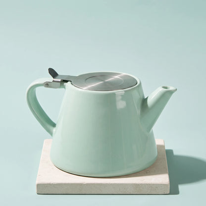 Muse ceramic teapot with infuser, Aqua Blue, on a stone tile