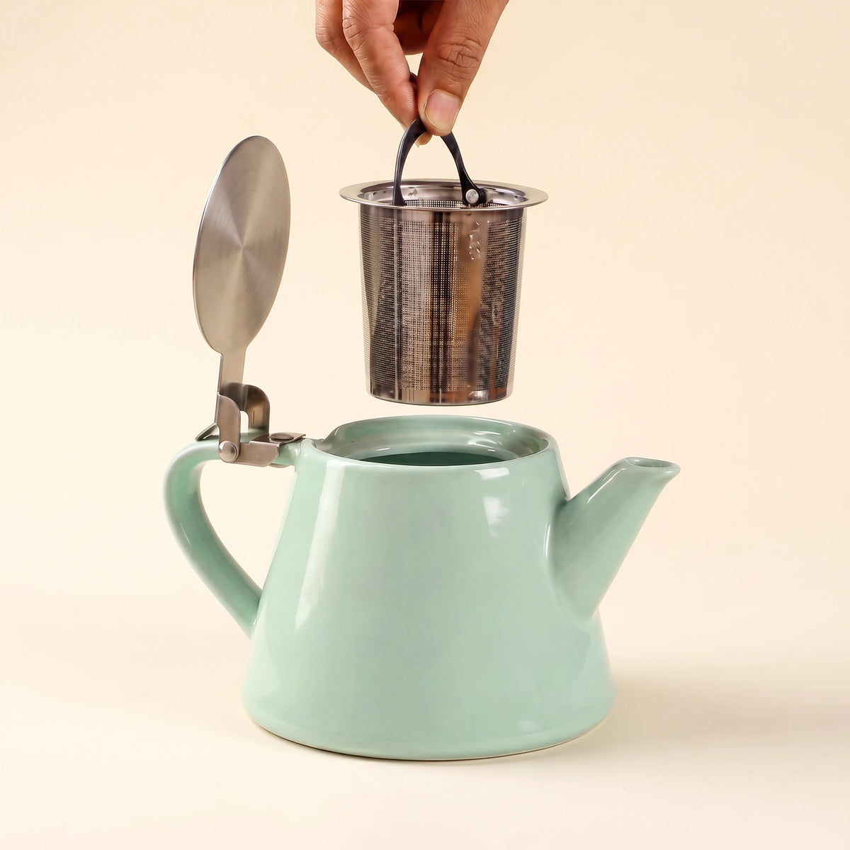 Muse ceramic teapot with infuser, Aqua Blue, infuser being lifted out of the teapot