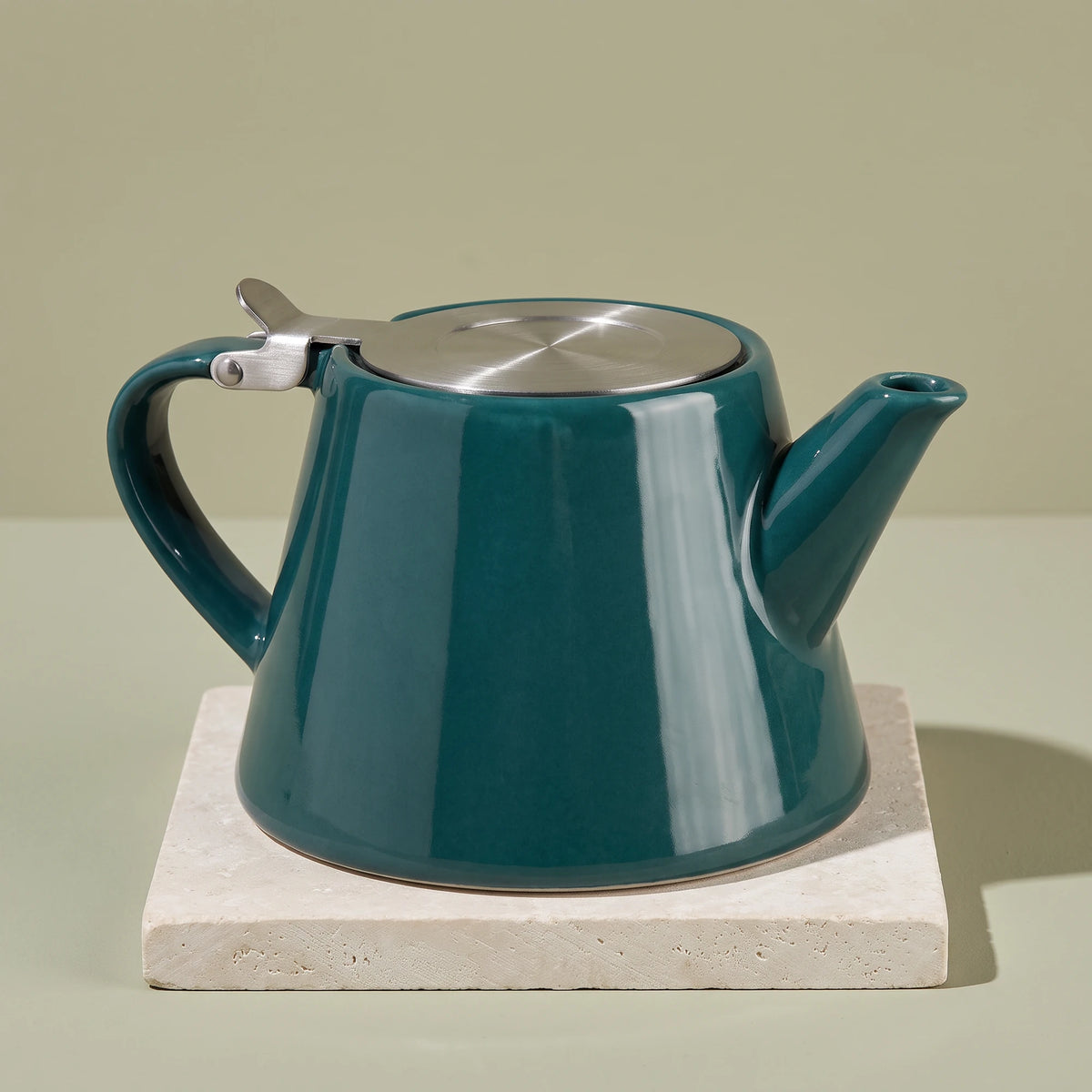 Muse ceramic teapot with infuser, Jade Green, on a stone tile