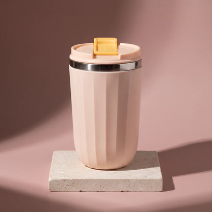 Opal travel tumbler, Blush Pink, on a stone tile, coloured backdrop