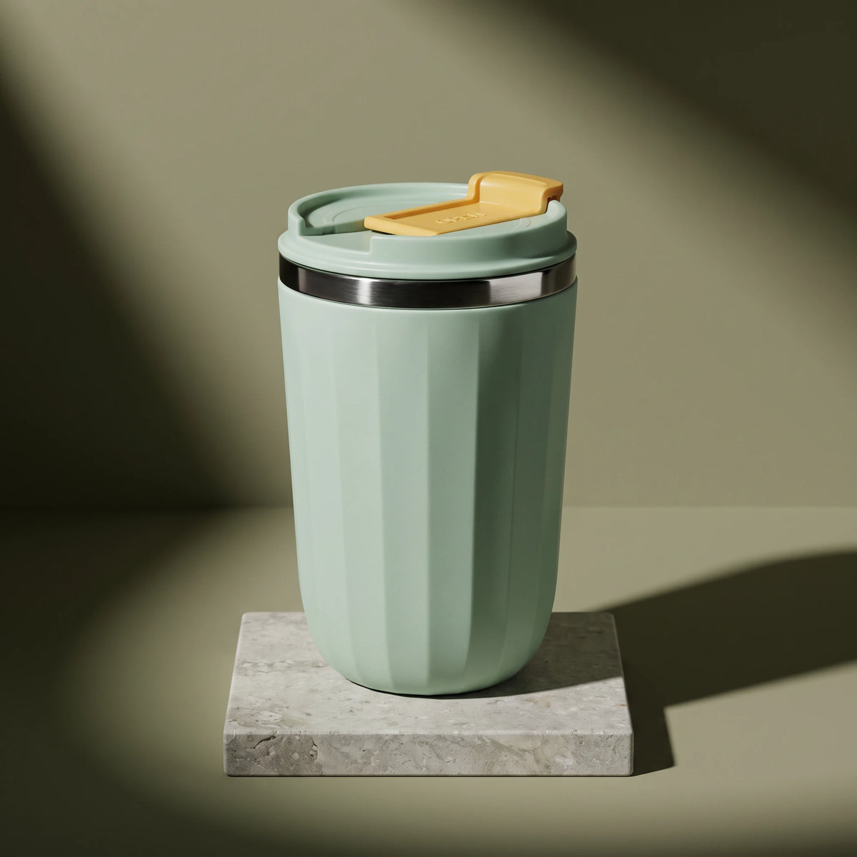 Opal travel tumbler, Sage Green, on a stone tile, coloured backdrop
