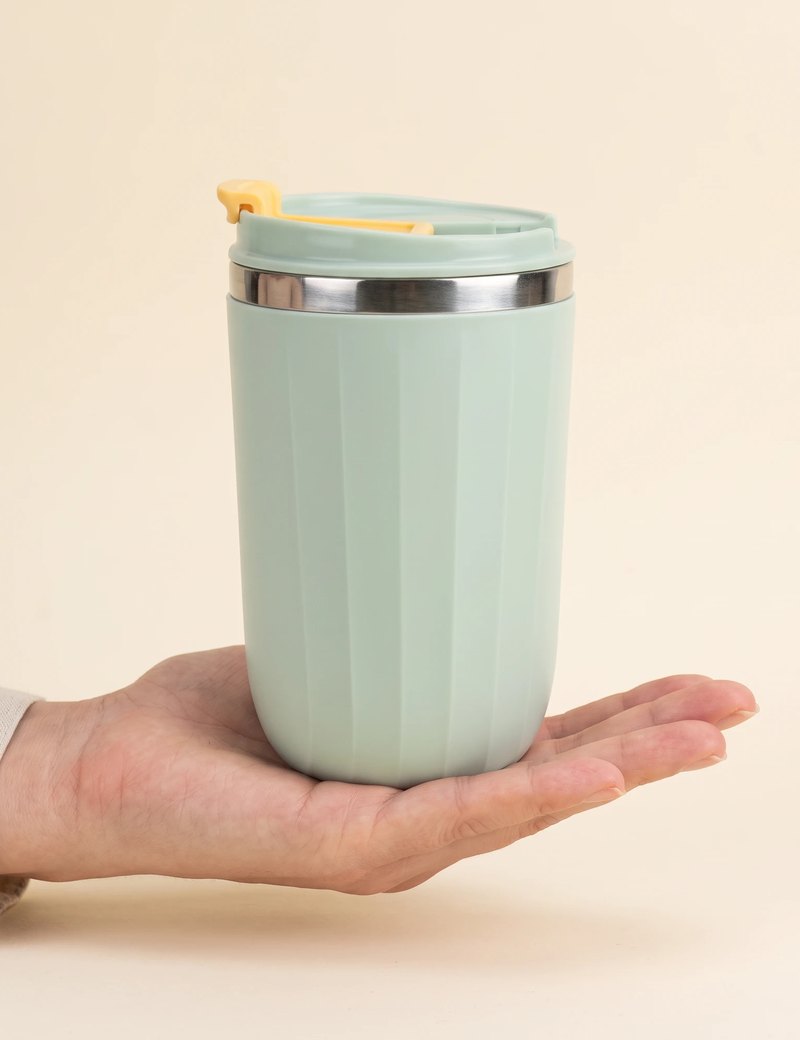 Opal travel tumbler, Sage Green, on an open hand