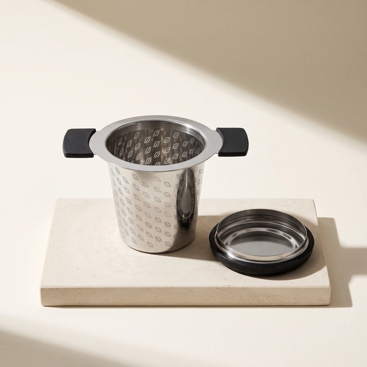 Perfect tea infuser, on a stone tile with its lid