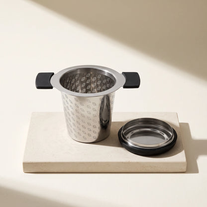 Perfect tea infuser, on a stone tile with its lid
