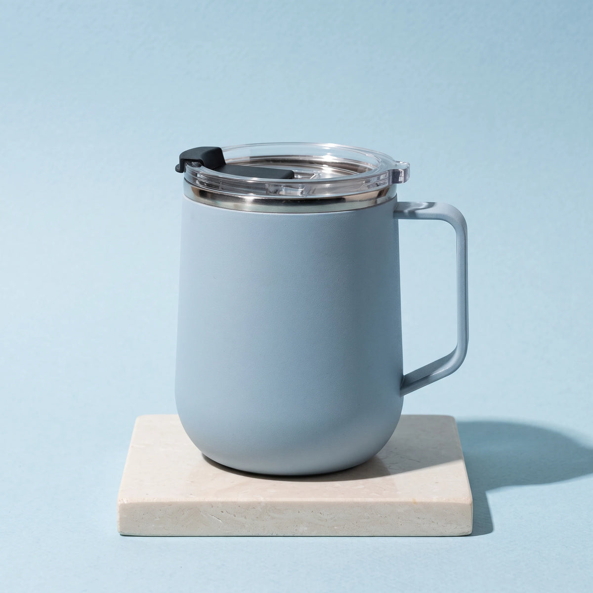Pulse travel mug, Frost Blue, on a stone tile