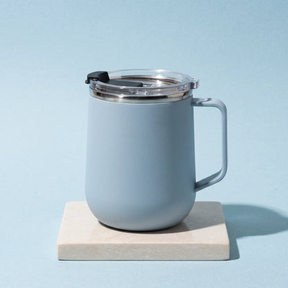 Pulse travel mug, Frost Blue, on a stone tile