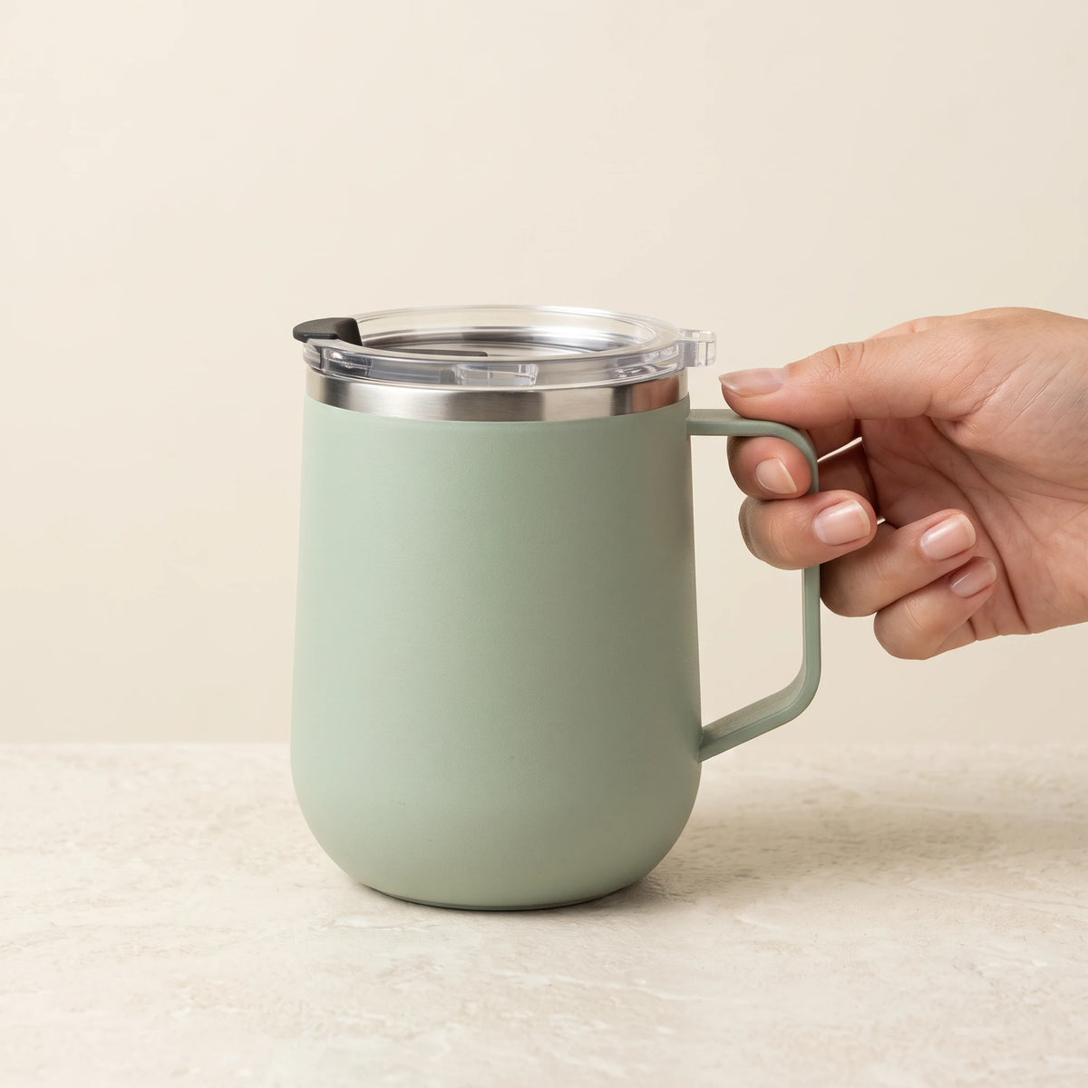 Pulse travel mug, Mint Green, held by the handle