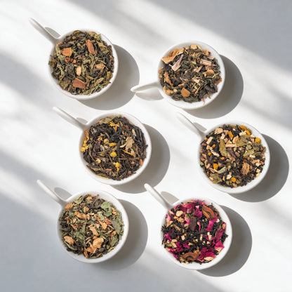 The six loose teas in the Wellness Tea Sampler Pack, in white bowls