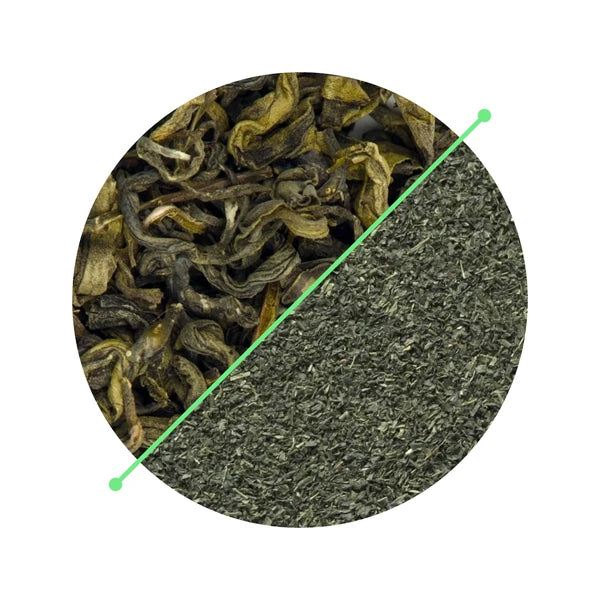 Whole tea leaves beside tea dust